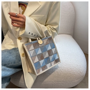Close-up of linen tote bag featuring blue plaid pattern and decorative wooden button