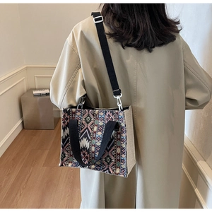 Detail of woven tote bag with geometric ethnic patterns and adjustable crossbody strap