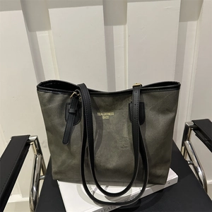 Detail of olive green tote bag with TidalDryness logo on a leather chair