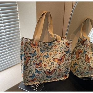 Detail view of woven butterfly floral pattern canvas tote bag with beige straps