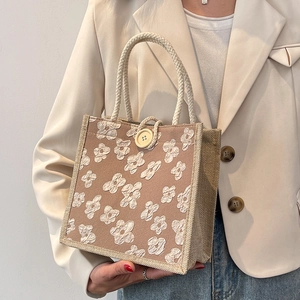 Minimalist beige linen handbag with white floral print and woven handles for women