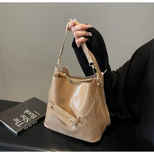 Detail of light brown PU leather bucket bag with gold chain and Fashion embossed strap