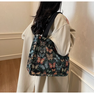 Detailed close-up of a floral butterfly jacquard tote bag with black woven straps