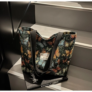 Macro detail of floral butterfly jacquard fabric texture and woven brand label on tote bag