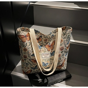 Detail of floral butterfly jacquard tote bag on stairs showing high-quality canvas fabric