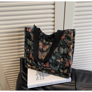 Detailed view of vintage butterfly jacquard fabric and black woven strap on tote bag