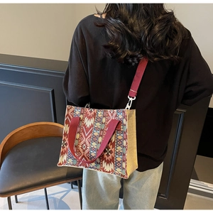 Close-up of ethnic patterned woven shoulder bag with burgundy straps and boho textures