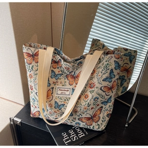 Detailed view of the woven floral jacquard fabric and brand label on a large tote bag