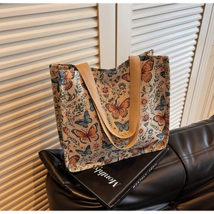 Detailed close-up of vintage butterfly floral jacquard fabric on a large tote bag