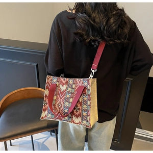 Detailed shot of ethnic print tote bag with vintage geometric patterns and red canvas straps