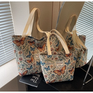 Detail view of floral butterfly embroidery patterns on cotton linen tote bag set