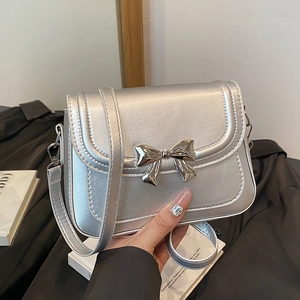 Sac bandoulière argenté avec nœud métallique et bandoulière réglable élégante