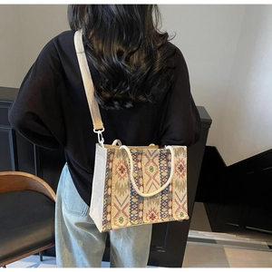 Lifestyle shot of geometric woven tote bag with rope handle and broad strap on model