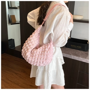 Pink crescent moon puffy shoulder bag showing soft bubble texture and adjustable strap
