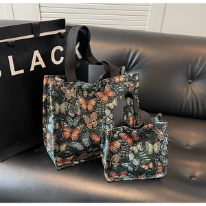 Close-up of vintage butterfly embroidered tote bag set with black fabric handles