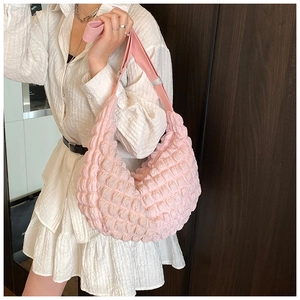 Pink crescent hobo bag featuring soft bubble pleated texture and adjustable strap