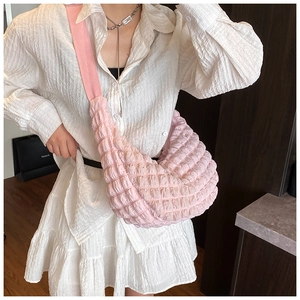 Detailed texture of pink bubble pleated cloud bag with soft crescent shape and strap