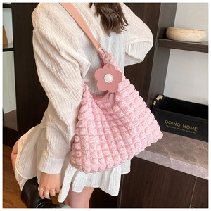Détail de la texture gaufrée plissée rose du sac fourre-tout avec charm floral