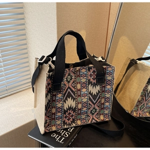 Detail of canvas tote bag with colorful ethnic weave pattern and black strap