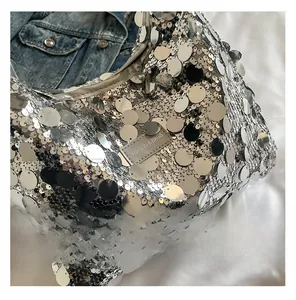Close-up of silver sequin tote bag with a fashion woven label and metallic reflection