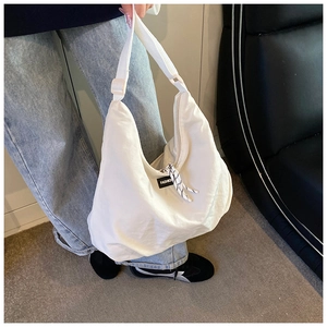 Dettaglio della borsa a mezzaluna in nylon bianco con tracolla regolabile e logo