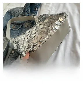 Detail of silver sequin tote bag with grey leather handle and mirrored finish