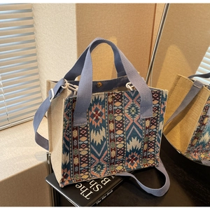 Detail of woven tote bag with blue ethnic geometric patterns and adjustable strap