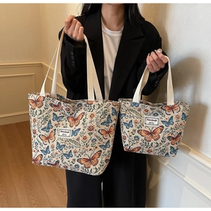 Close-up of floral tote bag set featuring orange butterflies and canvas texture detail