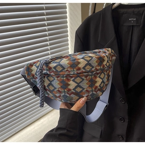 Detail of colorful geometric jacquard waist bag with light blue woven strap and zipper