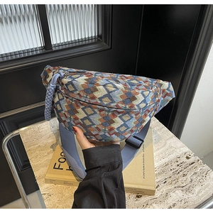 Detail of bohemian geometric woven chest bag with blue wide nylon strap and zipper