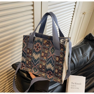 Detail of ethnic woven tote bag featuring blue geometric patterns on leather sofa