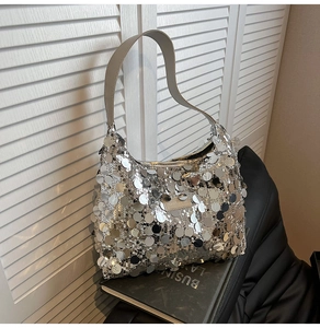Detail of silver sequin tote bag resting on books with a focus on metallic round sequins