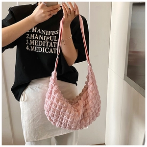 Pink pleated dumpling bag with soft texture shown worn on shoulder by a model