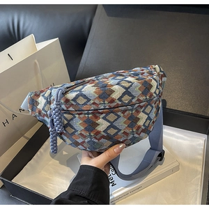 Detailed close-up of retro geometric jacquard chest bag with blue woven tassel zipper pull
