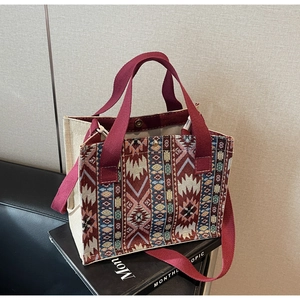 Detailed shot of ethnic geometric woven pattern on canvas tote bag with burgundy straps