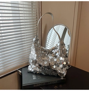 Close-up of silver sequin hobo bag with sleek shoulder strap on stylish books