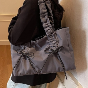 Grey-blue ruched shoulder tote bag with black ribbon bows and white stitching