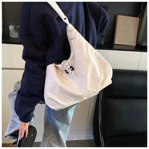 Vista laterale dettagliata di una borsa a tracolla bianca a mezzaluna con etichetta fashion