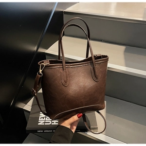 Detail of dark brown retro tote bag with premium PU leather texture and neat stitching