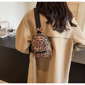 Rear view of a model wearing the leopard print mini crossbody bag on a beige coat