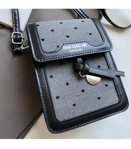 Gros plan du mini sac bandoulière rétro avec imprimé cœur et détail de nœud en cuir