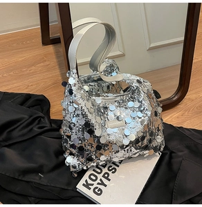 Close-up of sparkling silver sequins on tote bag with a leather fashion brand label