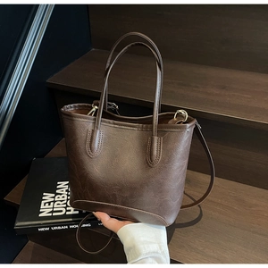 Close-up of brown vintage tote bag showing textured leather and gold hardware