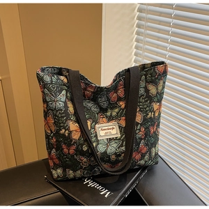 Detail of vintage canvas tote bag with butterfly prints and durable black handles