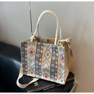 Detailed close-up of woven tote bag with colorful ethnic patterns and cotton rope handles