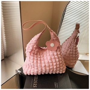 Détail du sac cabas rose texture gaufrée avec charm fleur et design plissé bulles