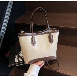 Detail of minimalist beige and brown patchwork tote bag on a wooden background