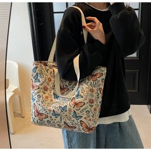 Macro view showing butterfly floral print texture and shoulder strap on canvas tote