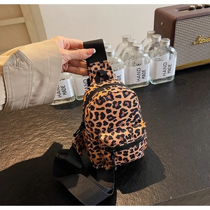 Close-up of mini leopard print backpack with multi-zipper pockets and black nylon straps