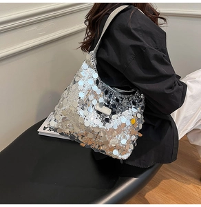 Close-up of silver sequin tote bag showing detailed stitching and grey leather handle